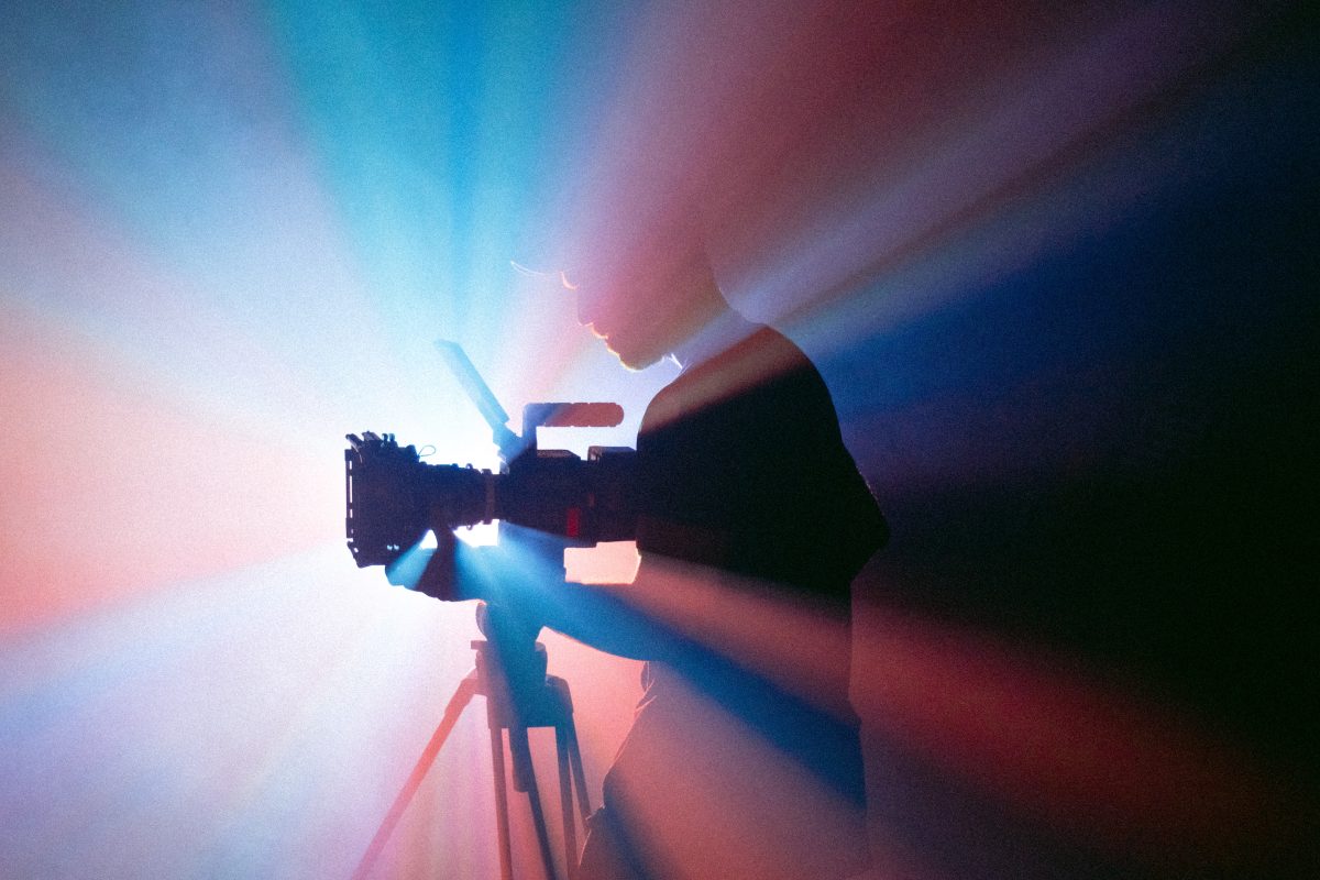a cameraperson with a camera on a tripod